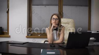 秘书女孩从工作中<strong>分心</strong>。 她坐在办公桌前，梦想着度假。